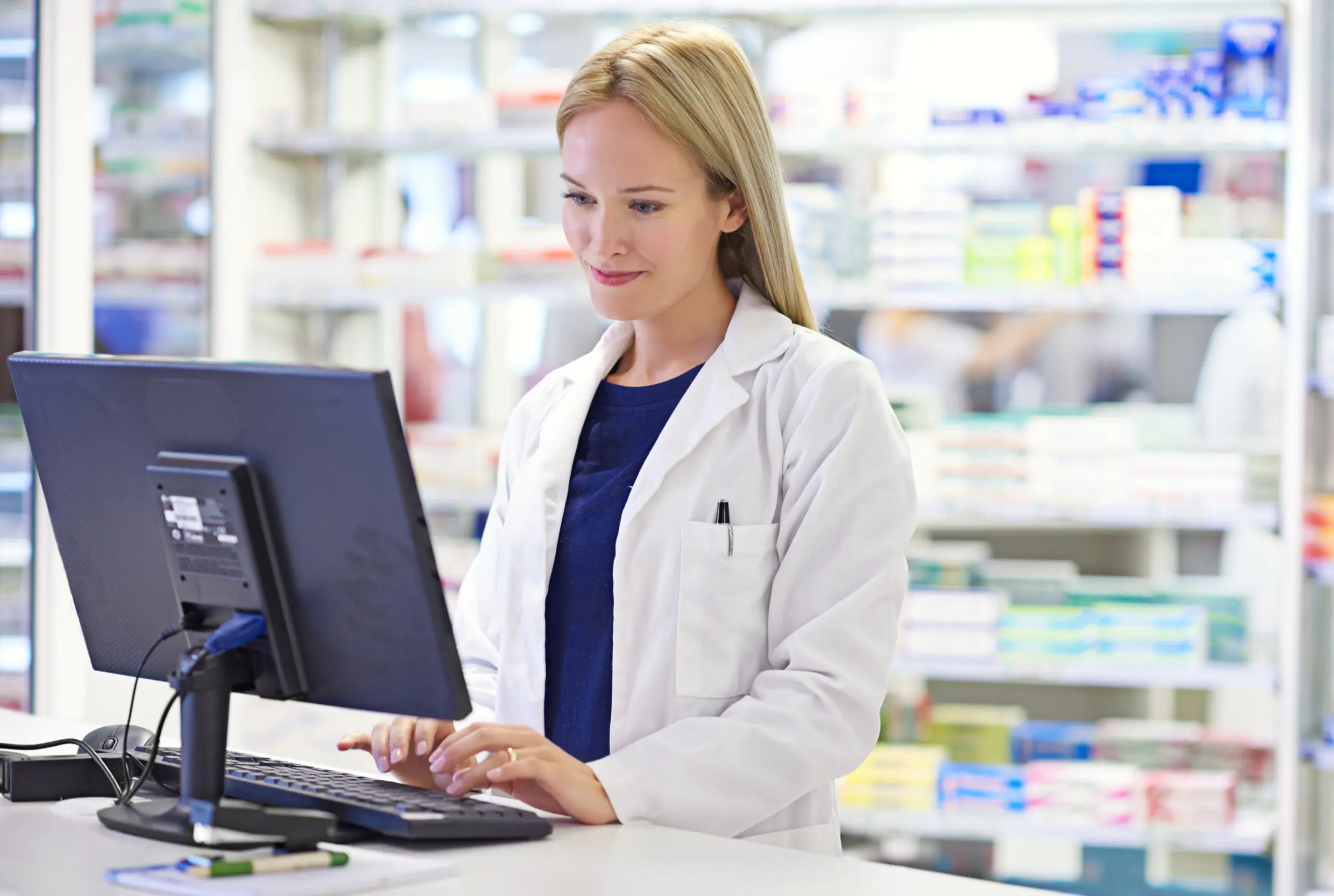 We monitor every customers history. Shot of an attractive pharmacist using a computer.